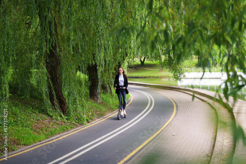 Wallpaper Mural A young woman walks along the path for an electric scooter in the city. Modern modes of transport Torontodigital.ca