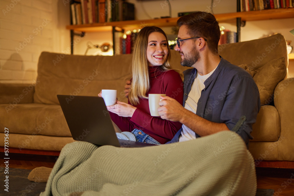 Young couple spending evening at home using laptop Young couple spending evening at home using laptop