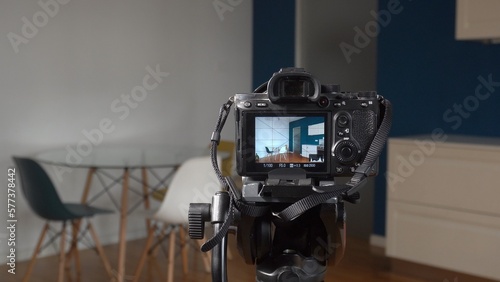 Man photographer taking pictures indoor in living room - real estate home photography and professional video to sell the house apartment - interior design and home staging 