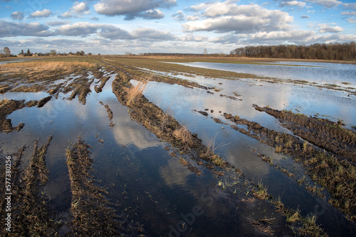 Spring very wet agricultural field with puddles of water due to rain and melting snow.