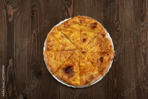 Baked homemade meat pie on wooden background.