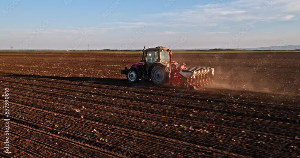 Farmer in tractor seeding soy beans at industrial agricultural farm Farmer in tractor seeding soy beans at industrial agricultural farm