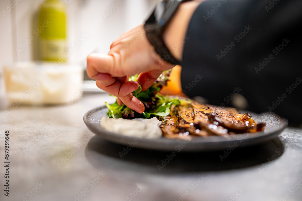 professional chef's hands cooking sliced meat beef brisket with salad and toast in restaurant kitchen