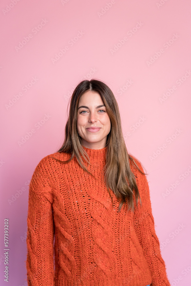 Smiling woman in sweater against pink background Smiling woman in sweater against pink background