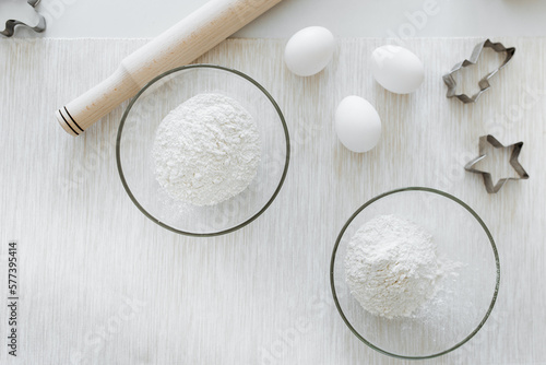 white flour in a glass dish with eggs on the table