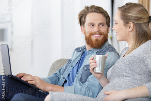 man and woman using laptop at home