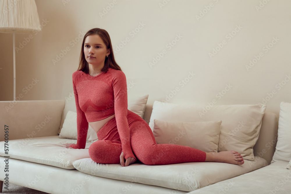 a woman does yoga at home in a comfortable environment in a pink suit a woman does yoga at home in a comfortable environment in a pink suit