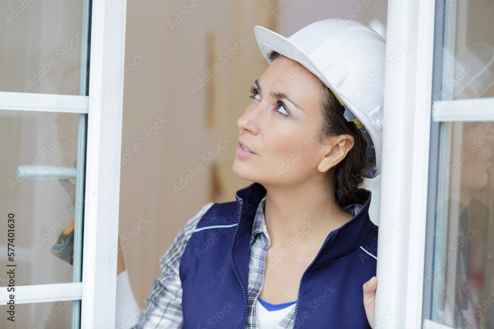 a female worker inspects a window a female worker inspects a window