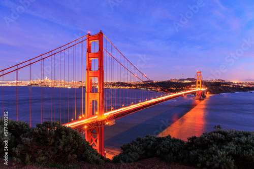 Car lights blur over Golden Gate Bridge and San Francisco lit at night