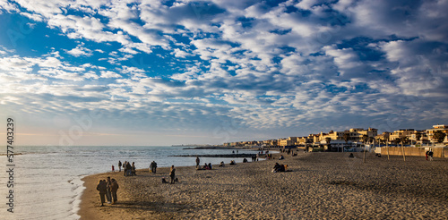 Fototapeta Naklejka Na Ścianę i Meble -  February 12, 2023 - Ostia, Rome, Italy. The sea of Ostia, on the Roman coast, on a winter Sunday. People enjoy the public holiday by walking on the beach in the open air in the evening.
