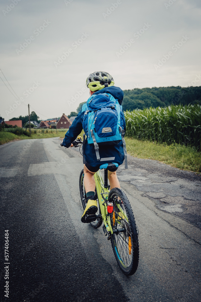 Bikepacking Abenteuer - Kleiner Junge auf einer Fahrradtour bei Regenwetter durch Niedersachsen, Deutschland
