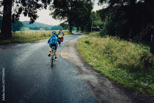 Fototapeta Naklejka Na Ścianę i Meble -  Bikepacking Abenteuer - Kleiner Junge und Mädchen auf einer Fahrradtour bei Regenwetter durch Niedersachsen, Deutschland