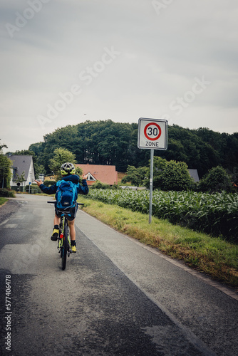 Bikepacking Abenteuer - Kleiner Junge auf einer Fahrradtour bei Regenwetter durch Niedersachsen, Deutschland