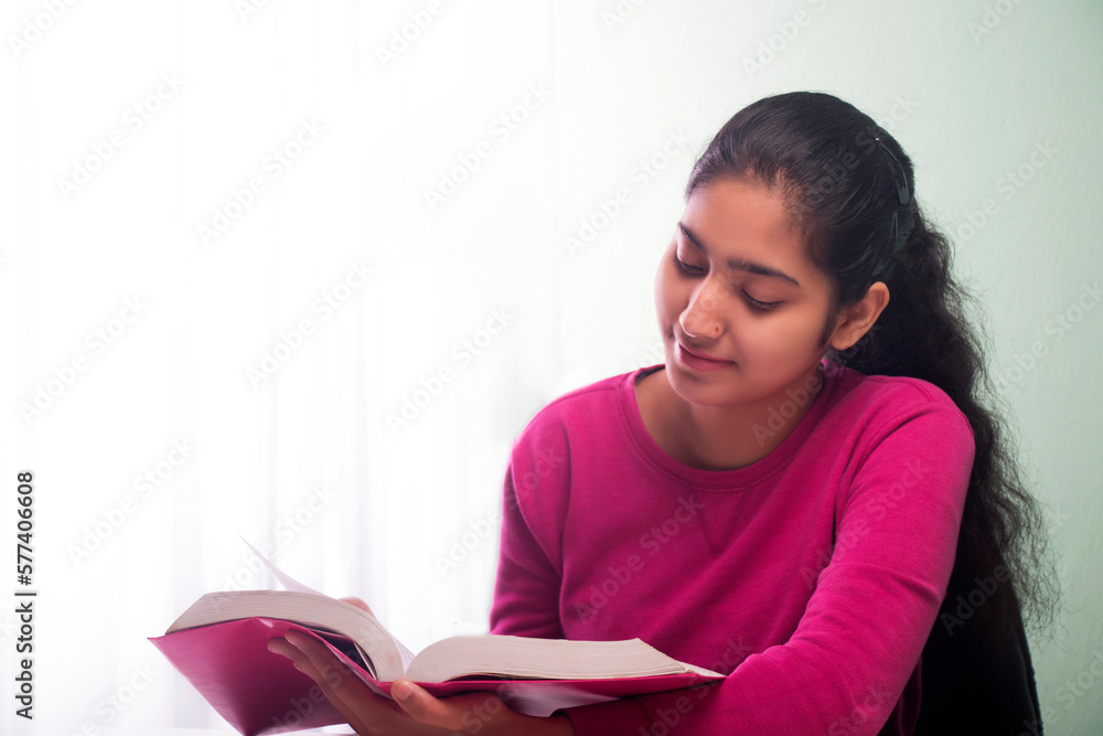Naklejka premium Young TEENAGER GIRL READING A BOOK
