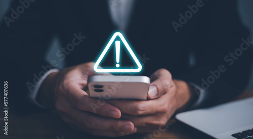 Error and maintenance alert. Businessman using computer laptop with triangle caution warning sing for notification error and maintenance concept.