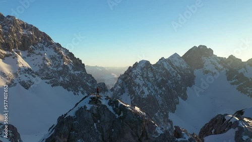 Mountaineer standing on Tajakopf mountain at sunset, Tirol, Austria photo