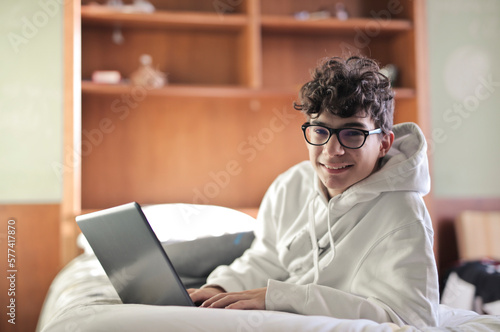 young boy on the bed with his computer