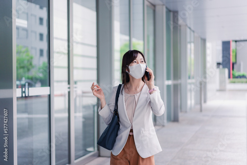 マスクをしてスマホを使う若い女性