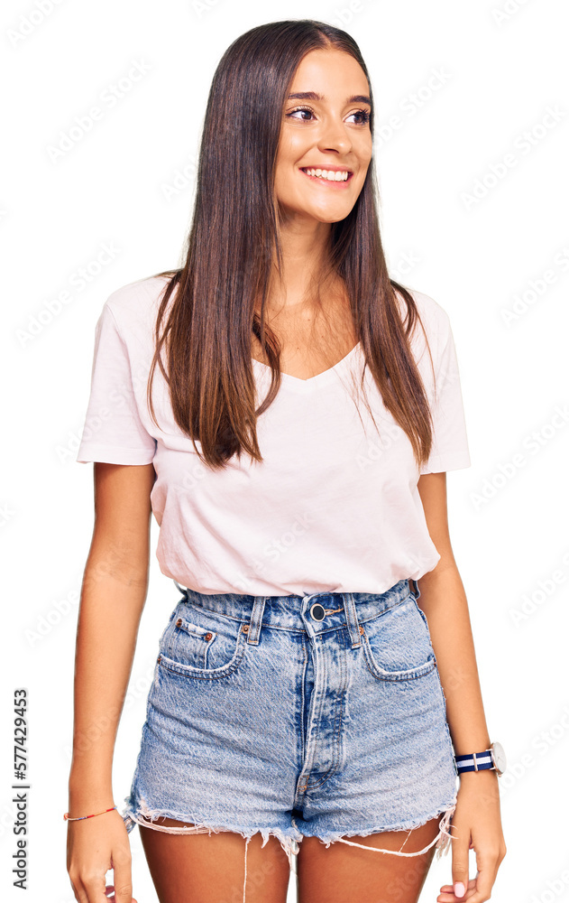 Obraz premium Young hispanic woman wearing casual white tshirt looking away to side with smile on face, natural expression. laughing confident.