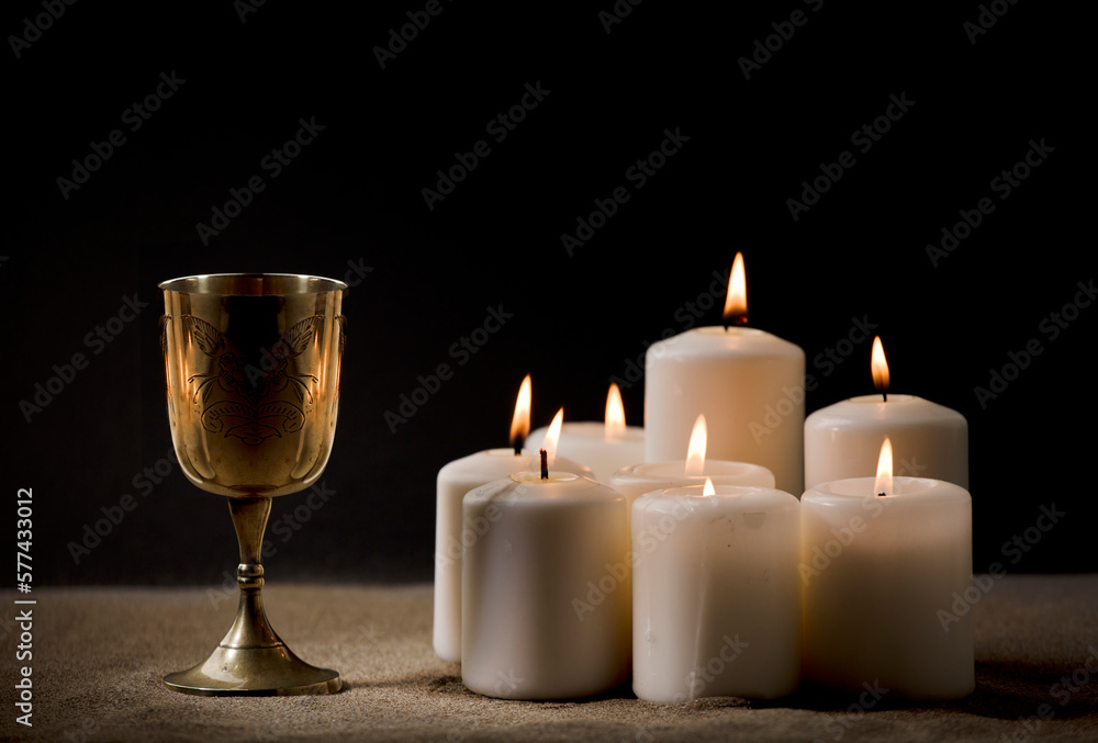 golden christian chalice on ground with burning candles black background night golden christian chalice on ground with burning candles black background night