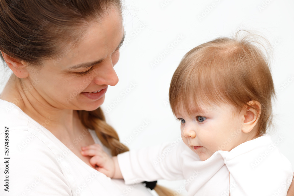 Bright portrait of happy mother holding infant child on hands. Mother hugging her little 6 months old baby. Bright portrait of happy mother holding infant child on hands. Mother hugging her little 6 months old baby.