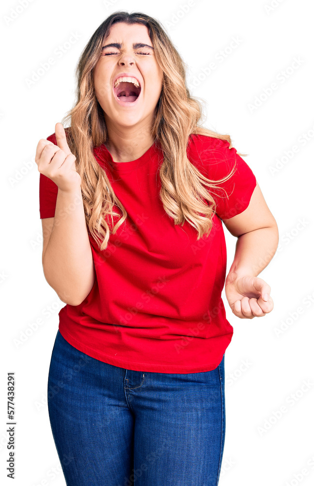 Young caucasian woman wearing casual clothes crazy and mad shouting and yelling with aggressive expression and arms raised. frustration concept. Young caucasian woman wearing casual clothes crazy and mad shouting and yelling with aggressive expression and arms raised. frustration concept.