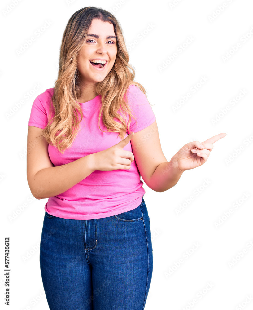 Young caucasian woman wearing sportswear smiling and looking at the camera pointing with two hands and fingers to the side. Young caucasian woman wearing sportswear smiling and looking at the camera pointing with two hands and fingers to the side.