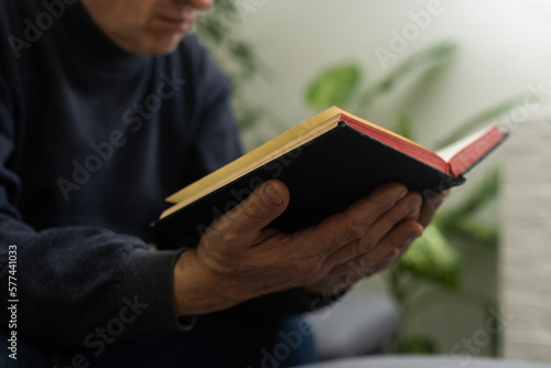 Senior man praying, holding Bible