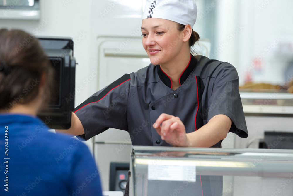 shop assistant talking to customer in a butchery shop assistant talking to customer in a butchery