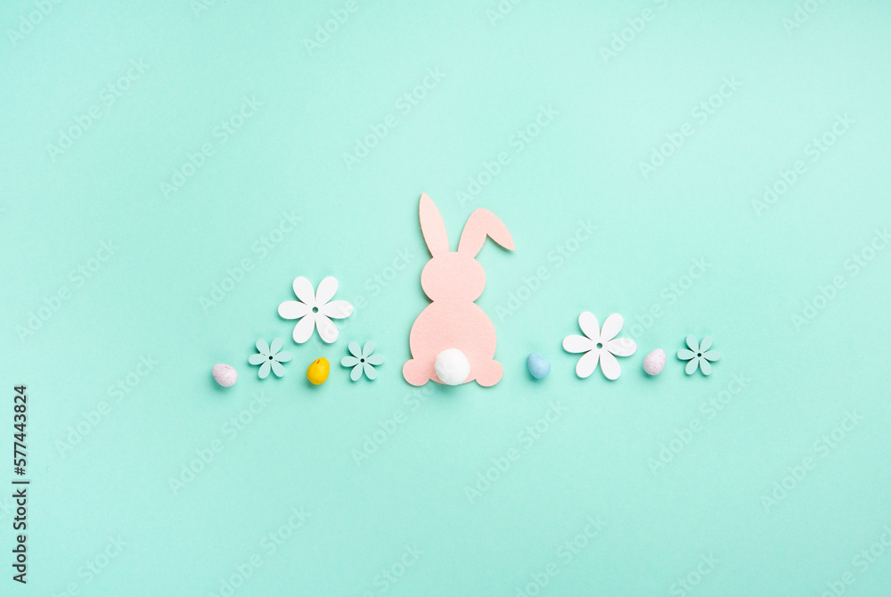 Pink Bunny, Easter Eggs with Sweets and Spring Flowers on Blue Mint Background Pink Bunny, Easter Eggs with Sweets and Spring Flowers on Blue Mint Background