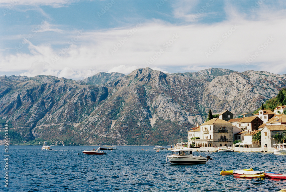 Coast of Perast with moored boats against the backdrop of the mountains. Montenegro