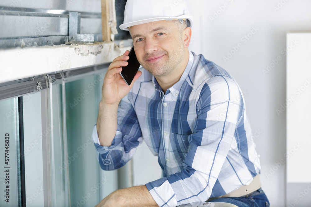middle-aged male builder ising a mobile telephone middle-aged male builder ising a mobile telephone
