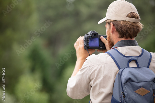 closeup of young man with digital camera outdoors