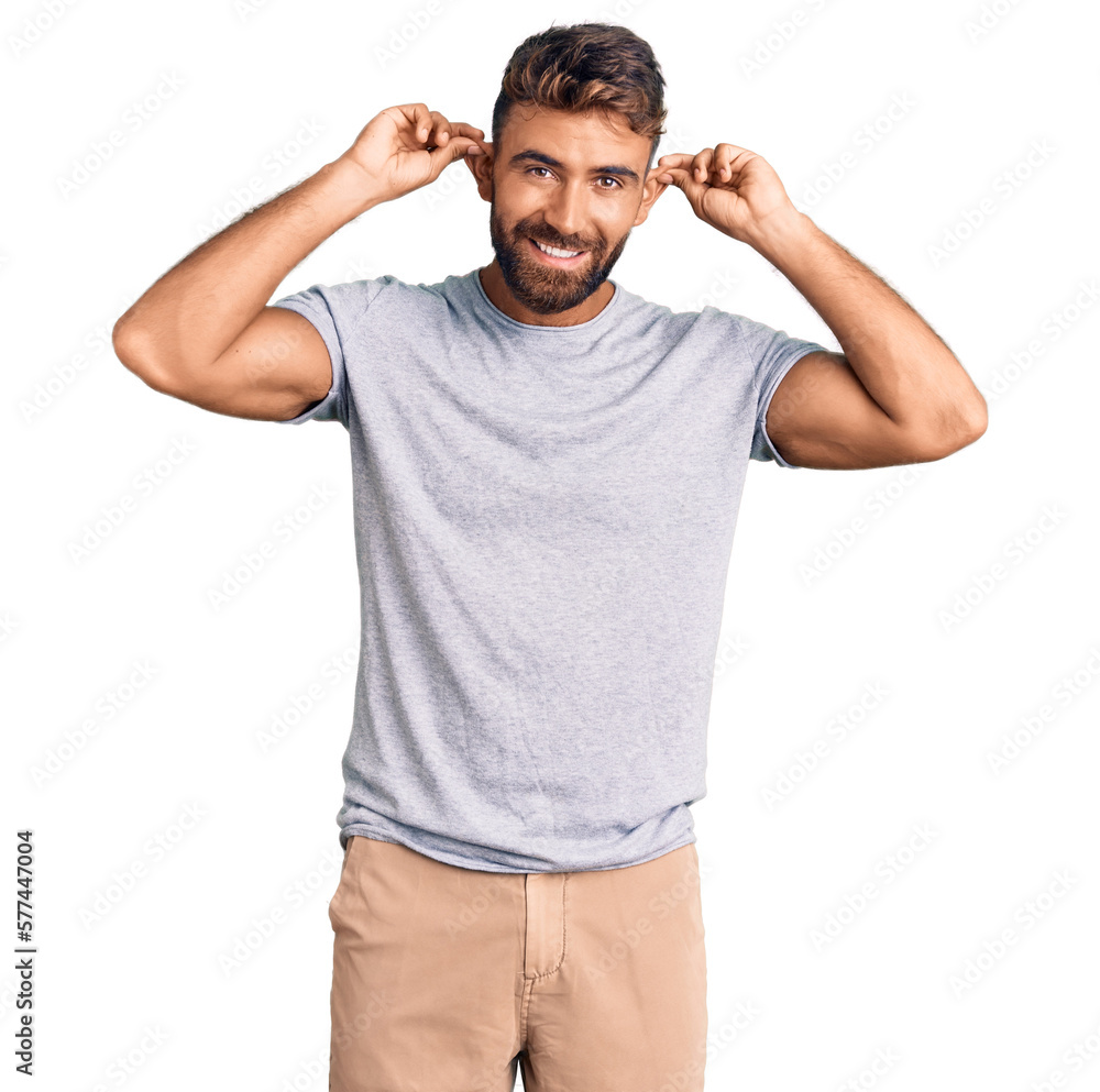 Young hispanic man wearing casual clothes smiling pulling ears with fingers, funny gesture. audition problem Young hispanic man wearing casual clothes smiling pulling ears with fingers, funny gesture. audition problem