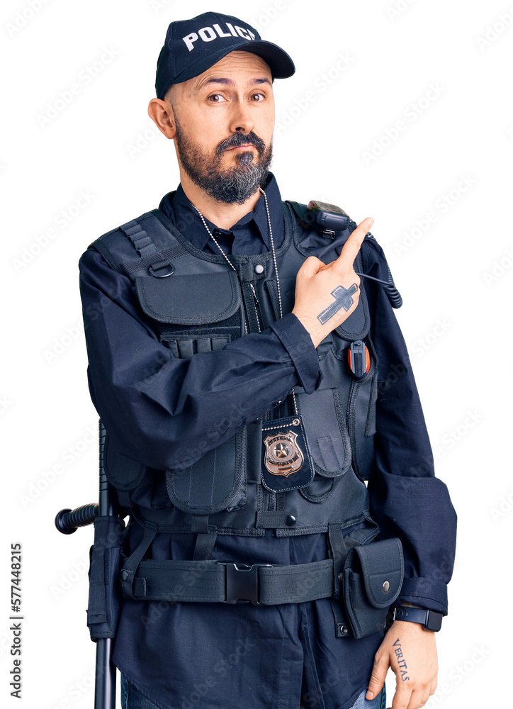 Young handsome man wearing police uniform pointing with hand finger to the side showing advertisement, serious and calm face Young handsome man wearing police uniform pointing with hand finger to the side showing advertisement, serious and calm face