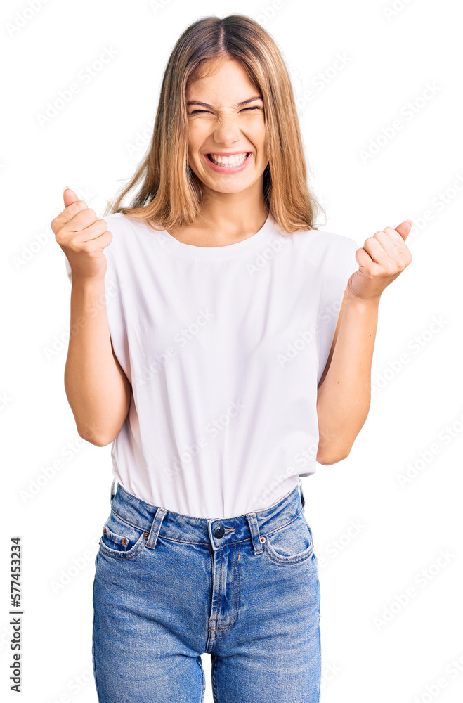 Beautiful caucasian woman with blonde hair wearing casual white tshirt excited for success with arms raised and eyes closed celebrating victory smiling. winner concept.