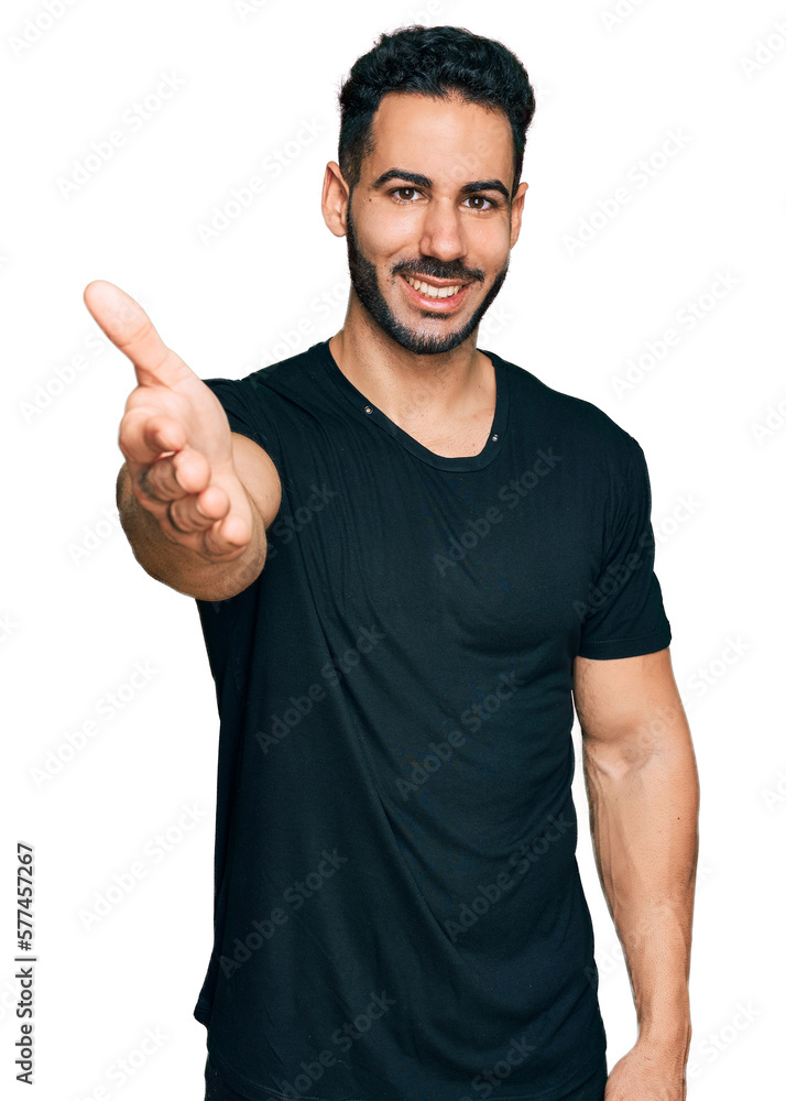 Hispanic man with beard wearing casual black t shirt smiling friendly offering handshake as greeting and welcoming. successful business. Hispanic man with beard wearing casual black t shirt smiling friendly offering handshake as greeting and welcoming. successful business.