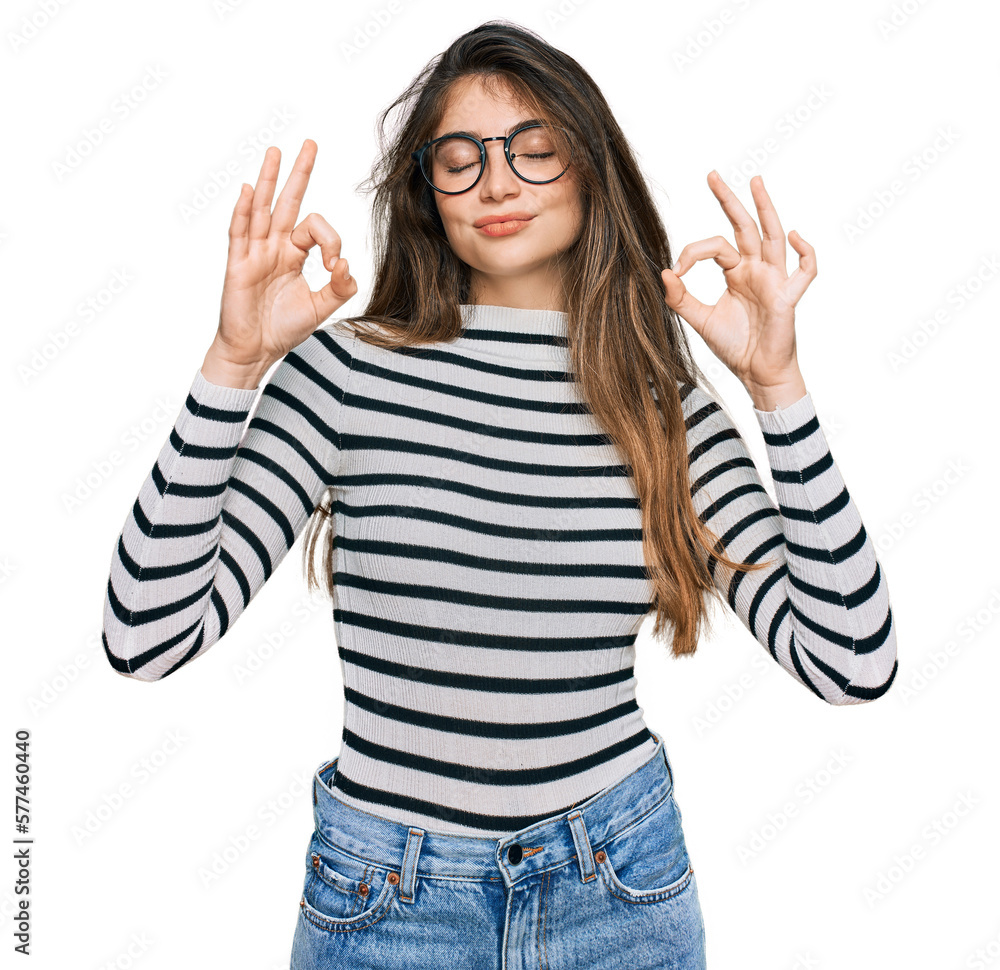 Young beautiful teen girl wearing casual clothes and glasses relax and smiling with eyes closed doing meditation gesture with fingers. yoga concept. Young beautiful teen girl wearing casual clothes and glasses relax and smiling with eyes closed doing meditation gesture with fingers. yoga concept.