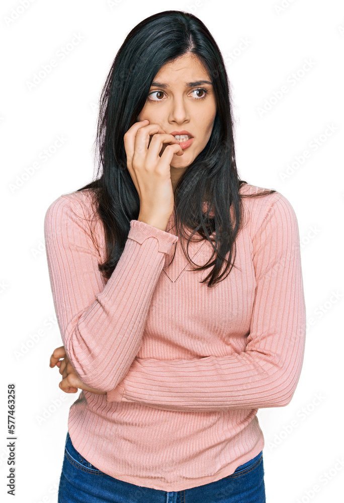 Young hispanic woman wearing casual clothes looking stressed and nervous with hands on mouth biting nails. anxiety problem. Young hispanic woman wearing casual clothes looking stressed and nervous with hands on mouth biting nails. anxiety problem.