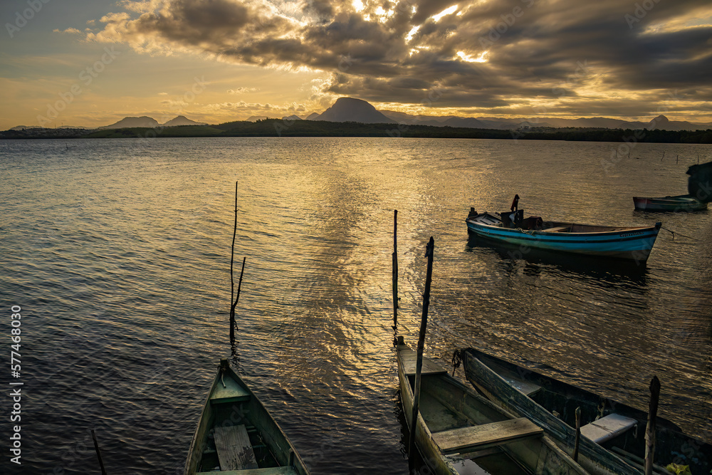 Photographic composition with wooden boats forming diagonal lines that lead the eye to the mountains at sunset Photographic composition with wooden boats forming diagonal lines that lead the eye to the mountains at sunset