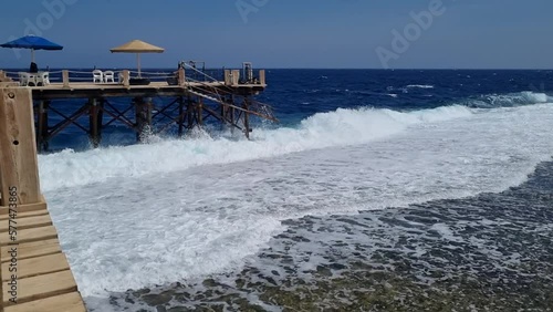 A pier in the sea against which the waves crash.