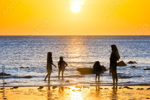 Fototapeta Naklejka Na Ścianę i Meble -  People on beach and sea sunset. Family with children on beach