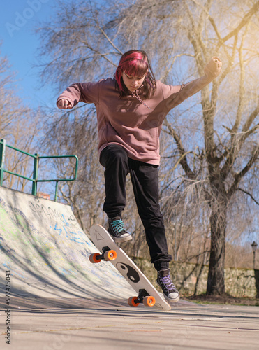 young girl doing a trick in a skate park