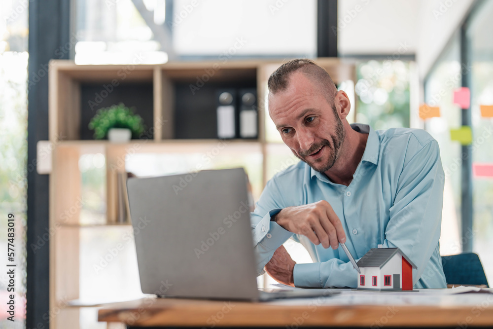 Professional and smart Caucasian male engineer having an online meeting with his team, explaining the building plan and design, working in the office. Professional and smart Caucasian male engineer having an online meeting with his team, explaining the building plan and design, working in the office.