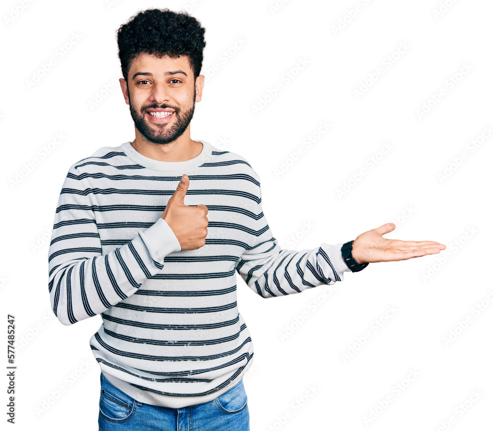 Young arab man with beard wearing casual striped sweater showing palm hand and doing ok gesture with thumbs up, smiling happy and cheerful Young arab man with beard wearing casual striped sweater showing palm hand and doing ok gesture with thumbs up, smiling happy and cheerful