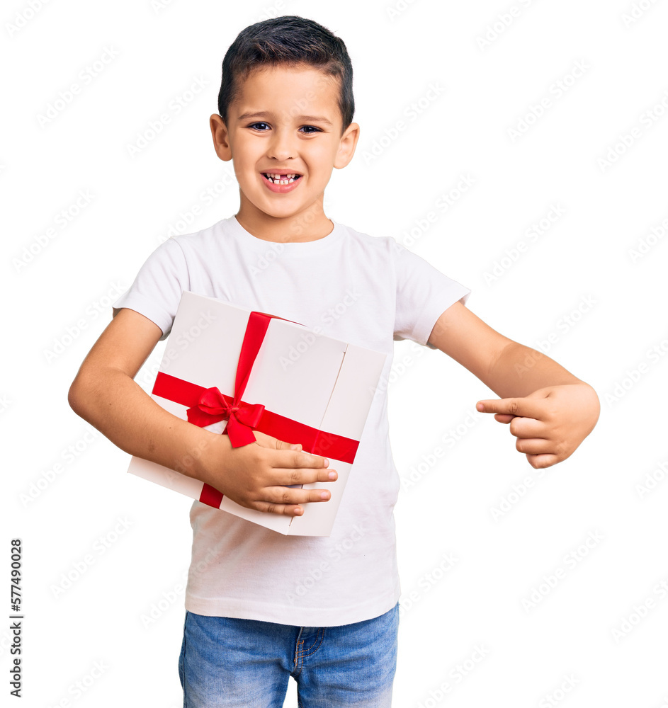 Little cute boy kid holding gift smiling happy pointing with hand and finger