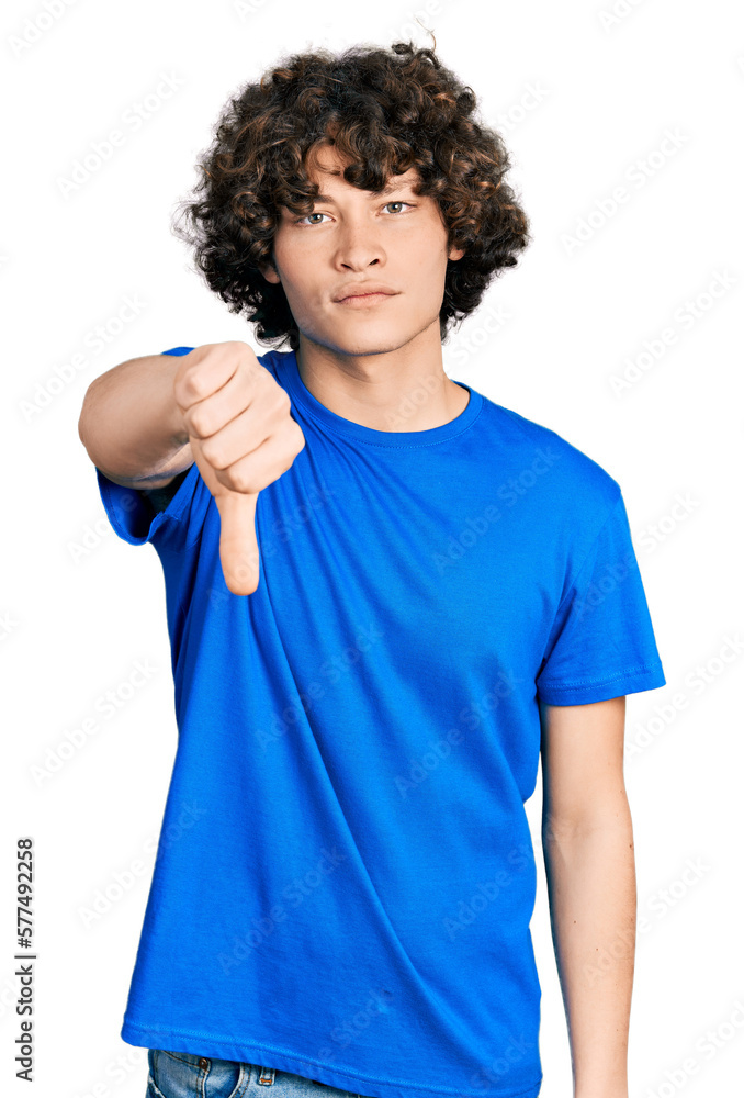 Caucasian teenager wearing casual clothes looking unhappy and angry showing rejection and negative with thumbs down gesture. bad expression. Caucasian teenager wearing casual clothes looking unhappy and angry showing rejection and negative with thumbs down gesture. bad expression.