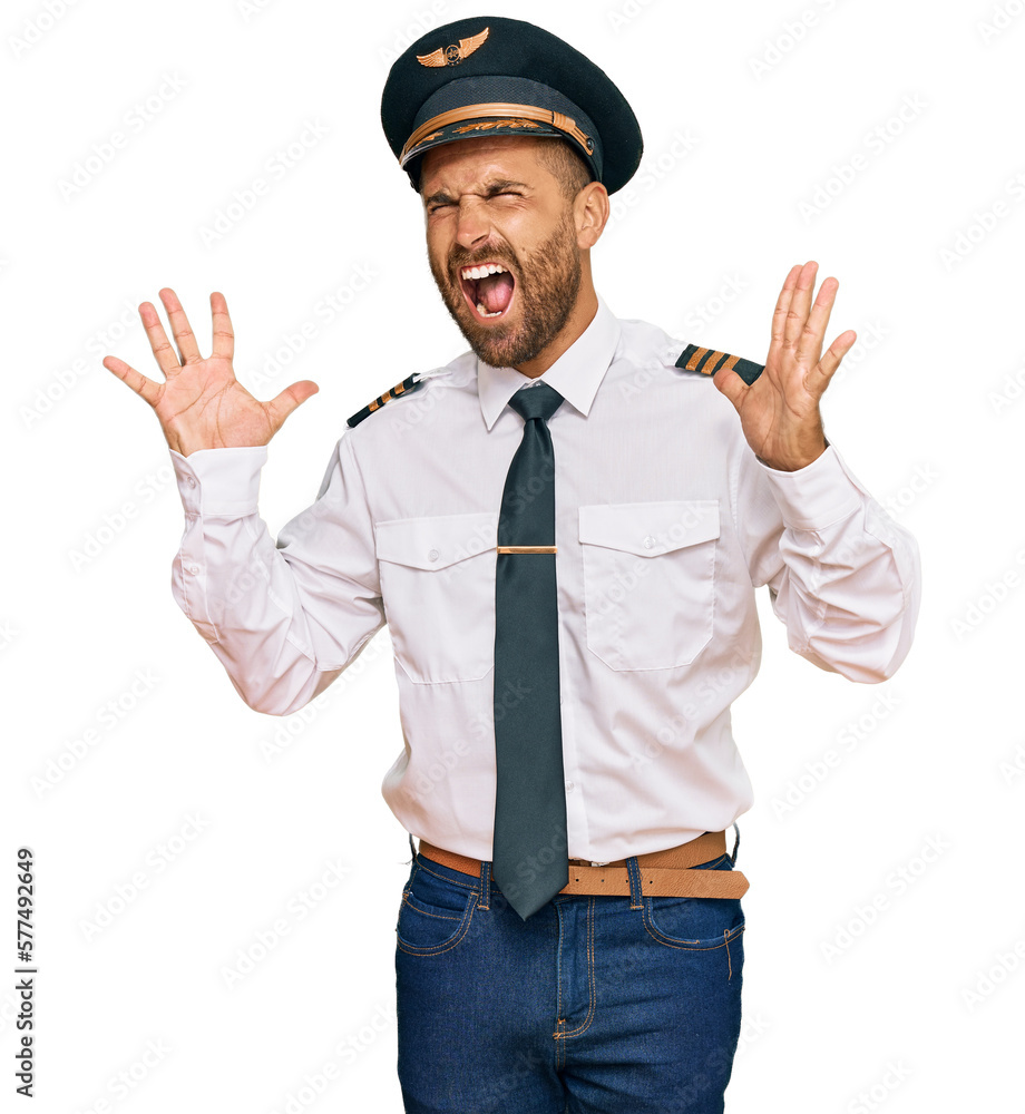 Handsome man with beard wearing airplane pilot uniform celebrating mad and crazy for success with arms raised and closed eyes screaming excited. winner concept Handsome man with beard wearing airplane pilot uniform celebrating mad and crazy for success with arms raised and closed eyes screaming excited. winner concept