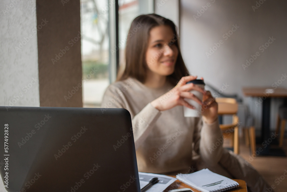 Young women working with laptop while sitting at café Young women working with laptop while sitting at café