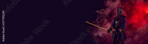 Bilde på lerret Man, professional kendo athlete, combat sportsman posing with shinai sword against gradient dark background in neon light with smoke